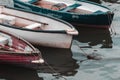 A zommed in shot of three weathered rowing boats resting in a cornish harbour.