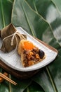 Zongzi. Rice dumpling for Dragon Boat Festival on green leaf background with ingredient