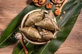 Zongzi, steamed rice dumplings on wooden table bamboo leaves, food in dragon boat festival duanwu concept, close up, copy space,