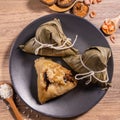 Zongzi, steamed rice dumplings on wooden table bamboo leaves, food in dragon boat festival duanwu concept, close up, copy space,