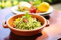 zoodles with pesto in a terracotta dish