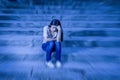 Zoom blur edited portrait of young sad and depressed woman or teen girl sitting lonely at street staircase looking desperate and s Royalty Free Stock Photo