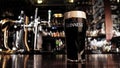 Zoom in on a glass of Guinness beer in a bar