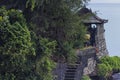 Zoom shot of a temple on top of a cliff with a staircase towards it in Tanah Lot, Bali Royalty Free Stock Photo