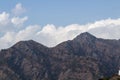 Zoom-in wide shot of beautiful mountain terrain with blue sky and clouds in the background Royalty Free Stock Photo