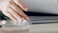 Zoom of woman hands, organise paper or search for document in paperwork stack on table at work. Lady use fingers to find