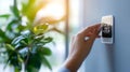 Zoomed-in image of a hand adjusting a smart thermostat in an energy-efficient building