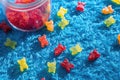 zoomed shot of colorful gummy bears scattered on a blue rug