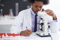 Zooming in on a virus. a male biologist looking at a glass slide through a microscope. Royalty Free Stock Photo