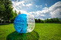 Zorbing Balloon on the summer lawn. inflatable zorb ball outdoor. Leisure activity concept with copy space