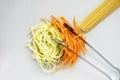 Zucchini and carrot with spaghetti on white chopping board