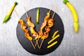 Zucchini and chicken kebab on wooden stick on black stone slate plate and grey background. Top view. Royalty Free Stock Photo