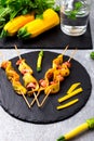 Zucchini and chicken kebab on wooden stick on black stone slate plate and grey background. Top view. Royalty Free Stock Photo