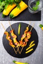 Zucchini and chicken kebab on wooden stick on black stone slate plate and grey background. Top view. Royalty Free Stock Photo