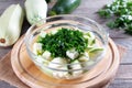 Zucchini cubes with herbs in a glass bowl on a table