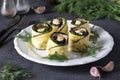 Zucchini and eggplant rolls with garlic and cream cheese on a plate on a dark gray background, close-up Royalty Free Stock Photo