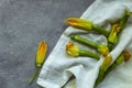 Zucchini flowers on white fabric. Flat lay, copy space Royalty Free Stock Photo