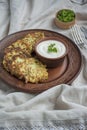 Zucchini fritters. Vegetarian zucchini crepes served with fresh herbs and sour cream. Light background Royalty Free Stock Photo