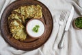 Zucchini fritters, vegetarian zucchini pancakes, served with fresh herbs and sour cream, top view. Light background Royalty Free Stock Photo