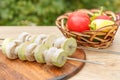 Zucchini and mushrooms on metal skewers on wooden chopping board