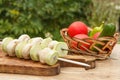 Zucchini and mushrooms on metal skewers on wooden chopping board Royalty Free Stock Photo