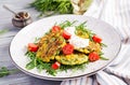 Zucchini pancakes with corn and sour cream served arugula