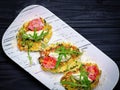 Zucchini pancakes served on white plate on dark wooden background Royalty Free Stock Photo