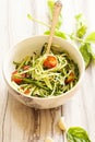 Zucchini pasta noodles with dressing in a white bowl