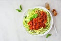 Healthy plant-based zucchini pasta topped with meatless walnut cauliflower bolognese, top view on a white marble background Royalty Free Stock Photo