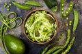 Zucchini spaghetti or noodles zoodles bowl with green veggies and garlic scape pesto. Top view, overhead.