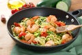 Zucchini noodles sauteed with cherry tomato and prawns in a pan