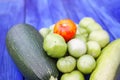 Zucchini and unripe tomatoes on wooden boards outdoors