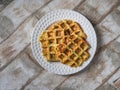 Zucchini waffles on a white plate on a wooden decorative table