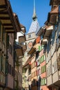 Zug, Switzerland - September 2016: Low angle view to the Zytturm clocktower through narrow streets with shuttered windows