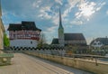 Zug, ZG / Switzerland - 20 April, 2019: view of the historic fortress Burg Zug and church of Saint Oswald in the city of Zug on a