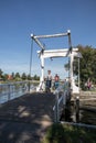 Couple riding bicycles over a wooden drawbridge over a canal