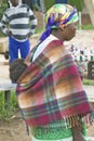 Zulu woman with child on her back dressed in brightly colored clothing, Zululand, South Africa Royalty Free Stock Photo