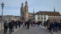 ZURICH, SWITZERLAND - JANUARY 1, 2023. The Grossmunster Cathedral as seen from crowded Munsterbrucke bridge