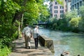 Zurich, Switzerland - July 13th 2019: Pedestrians using a beautiful walkway along an inner-city river