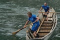 Man and women in a Swiss fisherman traditional wooden boat on sport event. Royalty Free Stock Photo