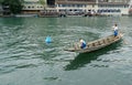 A Swiss fisherman traditional wooden boat with one small boy and woman.