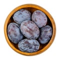 Zwetschge. Fresh and ripe European plums in a wooden bowl.