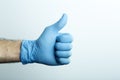 ÃÂ«LikeÃÂ» in a medical glove. Doctor`s hand in a blue medical glove on a light background Royalty Free Stock Photo