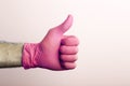 ÃÂ«LikeÃÂ» in a medical glove. Doctor`s hand in a pink medical glove on a light background Royalty Free Stock Photo