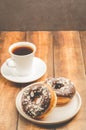 ÃÂÃÂ¡offee break. White cup with black coffee and donat in chocolate glaze. Wooden background