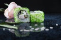 ÃÂ iece of sushi with caviar. Green land. Green caviar. Sushi on the glossy surface of the table