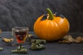 ÃÂ glass in the form of a skull and fall Halloween pumpkins on a dark background