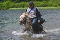 ÃÂ rider on a white horse wades across the river