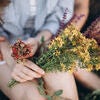Hands and legs of couple holding flowers and berries Stock Photo