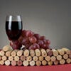 Red   wine glass with grape and corks. Stock Photo